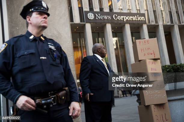 Security guard stands next to boxes of petitions left by protestors calling for the firing of Fox News television personality Bill O'Reilly in front...