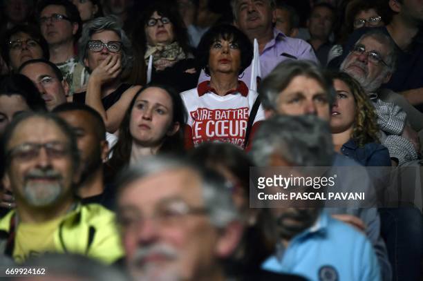 Supporters listen to the speech of French presidential election candidate for the left-wing French Socialist party during a campaign meeting on April...