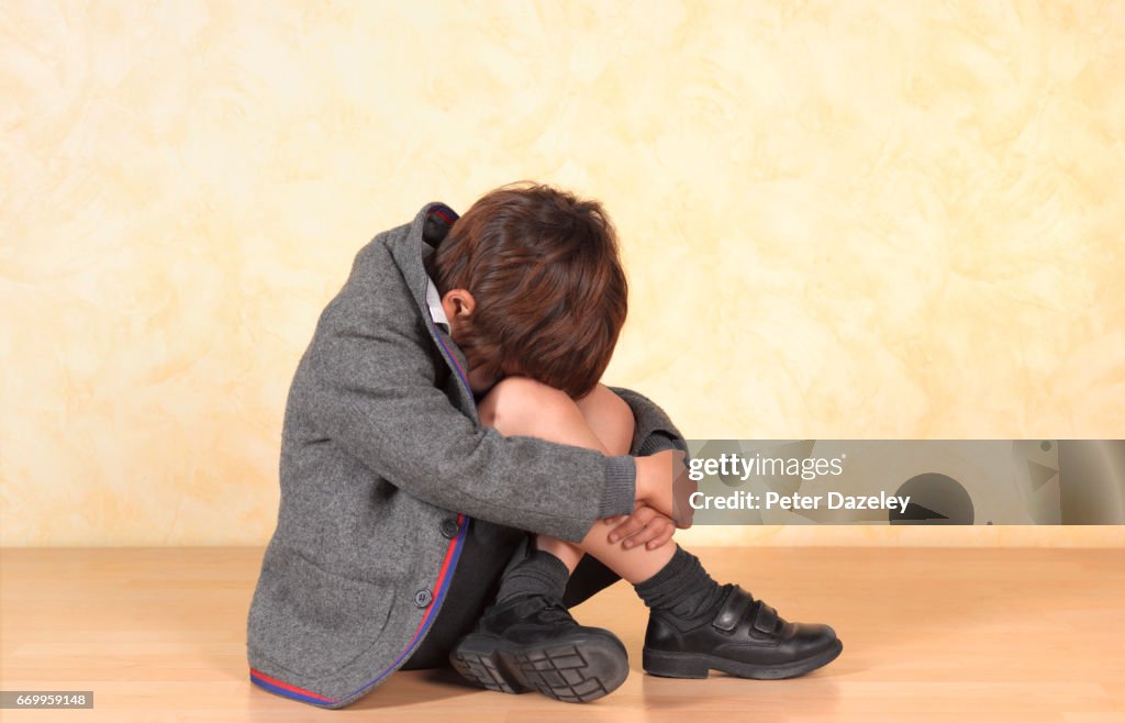 School boy sitting alone a poor child is bullied at school