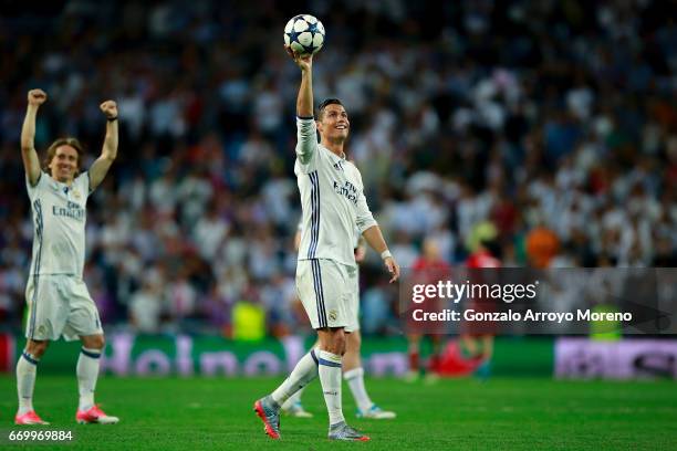 Cristiano Ronaldo of Real Madrid CF shows the ball as a gift for his hat trick after the UEFA Champions League Quarter Final second leg match between...