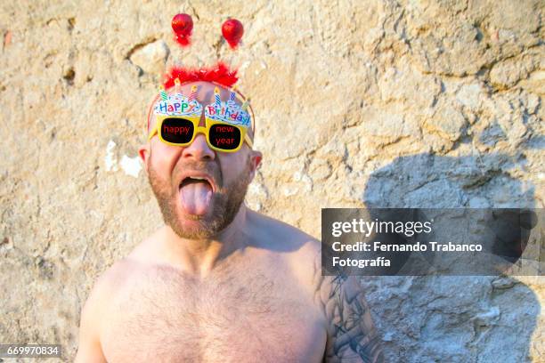 man puts out his tongue very happy celebrating new year - binge drinking stock pictures, royalty-free photos & images