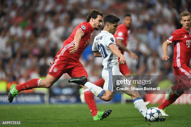 Marco Asensio of Real Madrid beats Mats Hummels of Bayern Muenchen to score their fourth goal during the UEFA Champions League Quarter Final second...