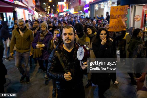 Man bangs on a pot, a reminder of Gezi Park Protests of 2013, in which people across Turkey protested agains the government, during a women's march...