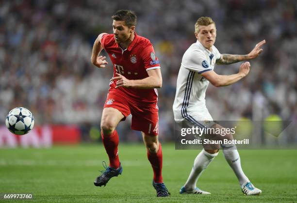 Xabi Alonso of Bayern Muenchen evades Toni Kroos of Real Madrid during the UEFA Champions League Quarter Final second leg match between Real Madrid...