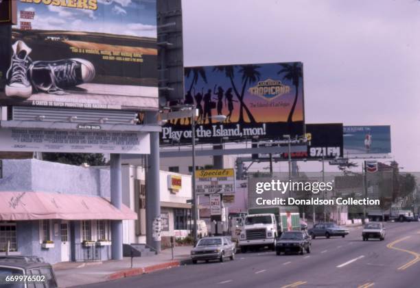 View of Sunset Blvd looking East from Marmont in January 1987 with a billboard for the Tropicana and a liquor stor and the Coconut Teaser and...