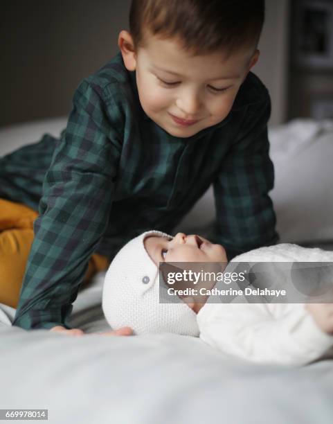 a 2 months old baby girl and her big brother - enfant blond stockfoto's en -beelden