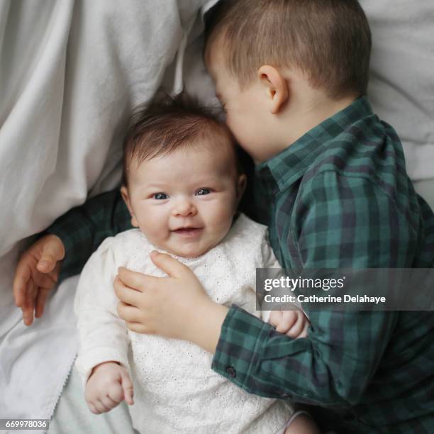 a 2 months old baby girl and her big brother - enfant blond stockfoto's en -beelden