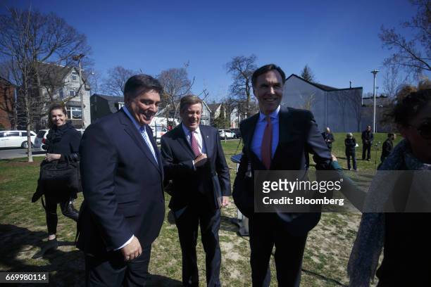 John Tory, mayor of Toronto, center, Charles Sousa, Ontario's finance minister, left, and Bill Morneau, Canada's finance minister, smile after a...
