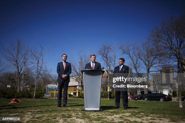 John Tory, mayor of Toronto, center, speaks while Charles Sousa, Ontario's finance minister, right, and Bill Morneau, Canada's finance minister,...
