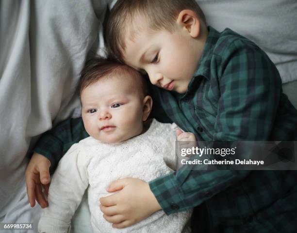 a 2 months old baby girl and her big brother - fratrie fotografías e imágenes de stock