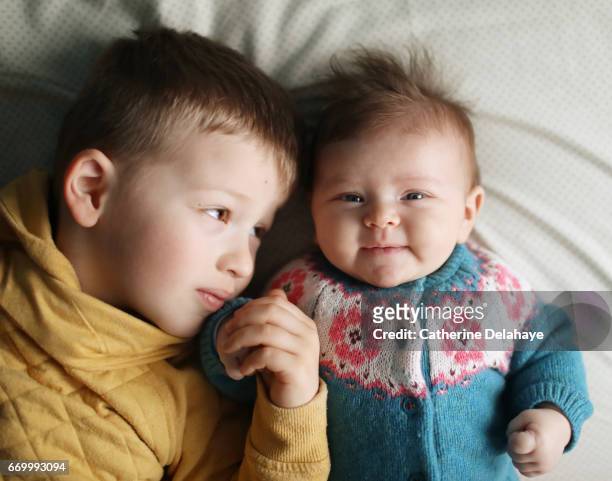 a 2 months old baby girl and her big brother - affectueux stock pictures, royalty-free photos & images