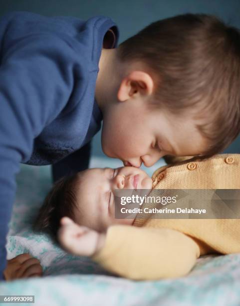 a 2 months old baby girl and her big brother - enfant blond stockfoto's en -beelden