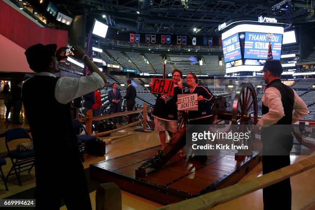 Pair of Columbus Blue Jackets fans pose for their picture with the Blue Jackets canon prior to the start of Game Four of the Eastern Conference First...