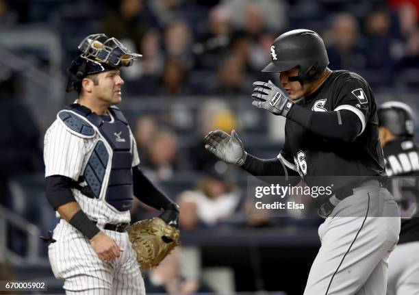 Avisail Garcia of the Chicago White Sox celebrates his three run home run as he crosses the plate with Austin Romine of the New York Yankees looking...