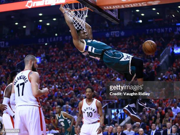 Giannis Antetokounmpo of the Milwaukee Bucks dunks the ball as Jonas Valanciunas of the Toronto Raptors looks on in the first half of Game Two of the...