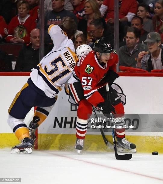 Trevor van Riemsdyk of the Chicago Blackhawks tries to control the puck under pressure from Austin Watson of the Nashville Predators in Game One of...