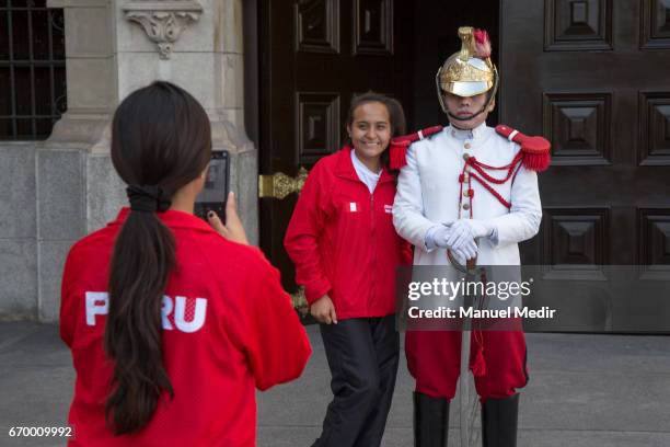 Athletes pose for photos alongside a gaurd of the palace after President of Peru Pedro Pablo Kuczynski received the Delegation of 33 Peruvian...