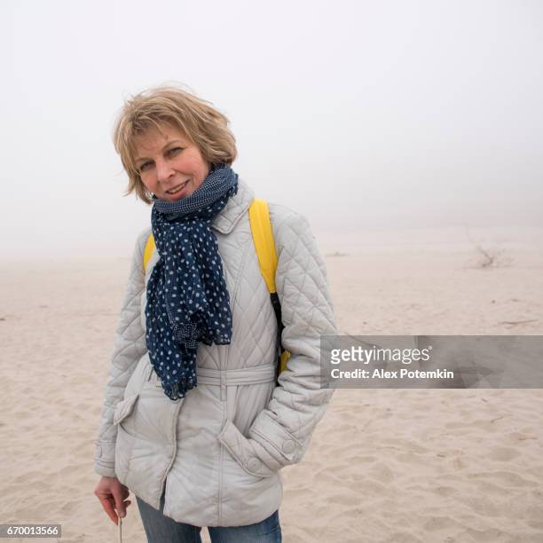 portret van de aantrekkelijke, vrolijke volwassen 50-jaar oude vrouw op het strand - 50 54 years stockfoto's en -beelden