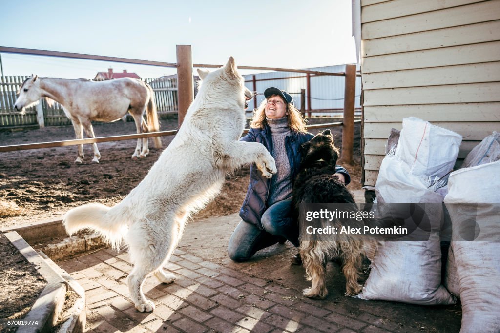 Mature, 40 ans, femme jouant avec deux chiens