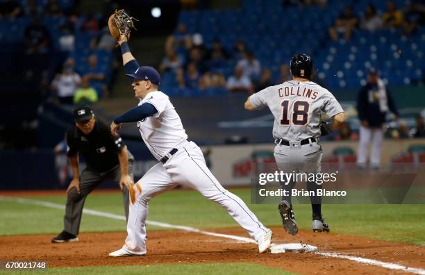 Tyler Collins of the Detroit Tigers gets to first base ahead of the throw to first baseman Logan Morrison of the Tampa Bay Rays after grounding into...