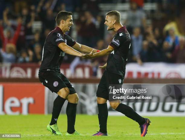 Nicolas Pasquini of Lanus celebrates with teammate Ivan Marcone after scoring the fifth goal of his team during a group stage match between Lanus and...