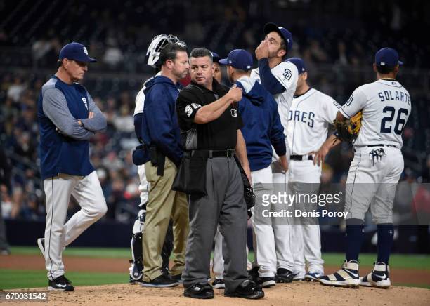 Umpire Rob Drake stands on the mound as Jarred Cosart of the San Diego Padres is taken out of the game during the fourth inning of a baseball game...