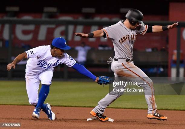 Joe Panik of the San Francisco Giants stands up on second for a stolen base past the tag of Raul Mondesi of the Kansas City Royals in the 11th inning...