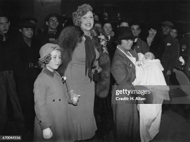 Novelist Barbara Cartland, with her daughter Raine at the christening of her son Ian Hamilton McCorquodale, 24th November 1937. The ceremony took...