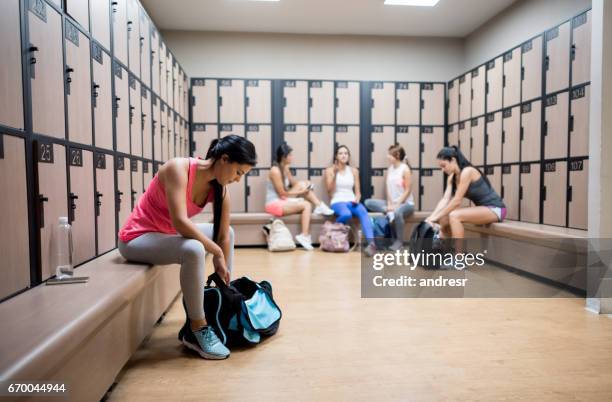 femmes a changer dans le vestiaire de la salle de gym - vestiaires casier sport photos et images de collection