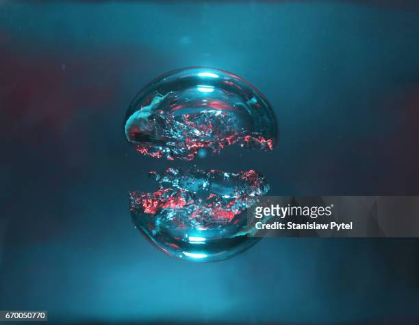two bubbles of air, blue and red, forming two halves of a sphere - wasser blasen stock-fotos und bilder