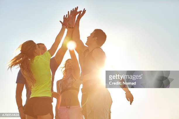 atleti ad alto fiving dopo un allenamento di successo - sportiva foto e immagini stock