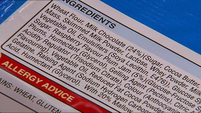 Food additives could be harmful to children; Labels on food packaging showing ingredients and additives Bags of food into trolley... Stock Footage Video