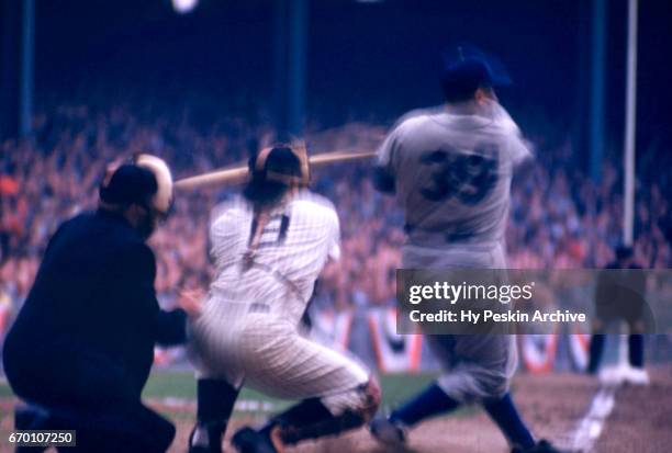 Catcher Roy Campanella of the Brooklyn Dodgers swings at a pitch as catcher Yogi Berra of the New York Yankees looks to catch the ball during a 1955...