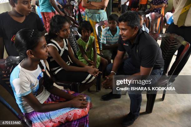 Sri Lankan cricketer Rangana Herath meets with survivors and displaced people at a relief camp after a massive garbage mountain collapse in the...