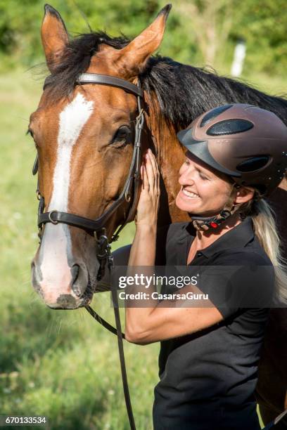 retrato de hermosa mujer con su caballo - riding hat fotografías e imágenes de stock