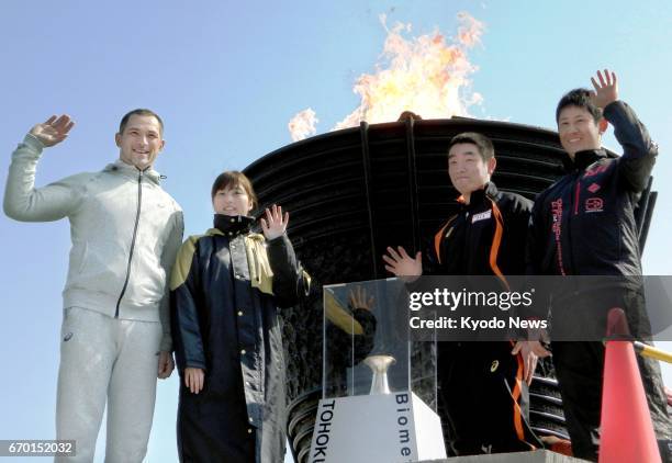 Koji Murofushi , the 2004 Athens Olympic Games men's hammer throw gold medalist, poses with local students in front of the borrowed 1964 Olympic...