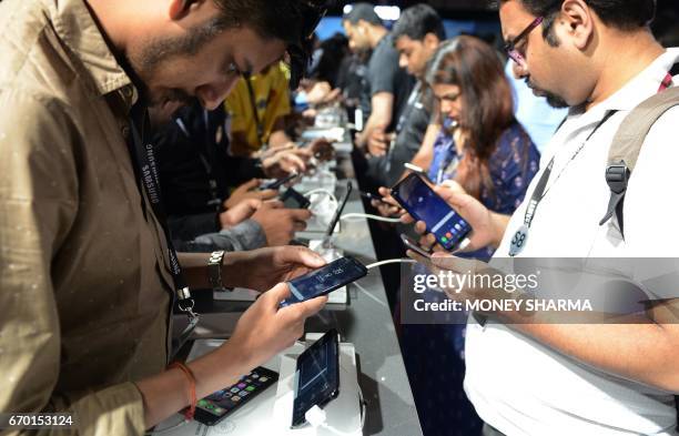 People look at the newly launched Samsung Galaxy S8 and Galaxy S8+ smartphones during an event in New Delhi on April 19, 2017. / AFP PHOTO / MONEY...