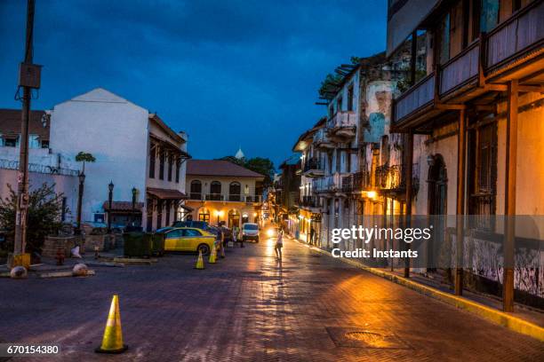 night shot of casco viejo also called casco antiguo, panama city’s old quarter established in 1673, with its old buildings and an unrecognizable person in background. - panama stock pictures, royalty-free photos & images