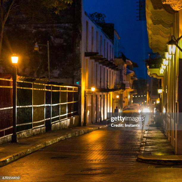 schuss in der abenddämmerung, casco viejo auch genannt casco antiguo, panama-stadt altstadt, gegründet im jahre 1673, mit alten gebäuden, autos und nicht erkennbare personen im hintergrund. - casco viejo stock-fotos und bilder