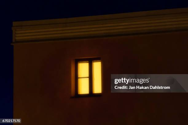 lit window in apartement house - spooky night stock pictures, royalty-free photos & images