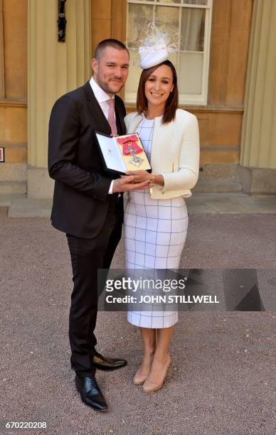 Former British track and field athlete, Jessica Ennis-Hill,, accompanied by her husband Andy, holds her award after she was made a Dame Commander of...