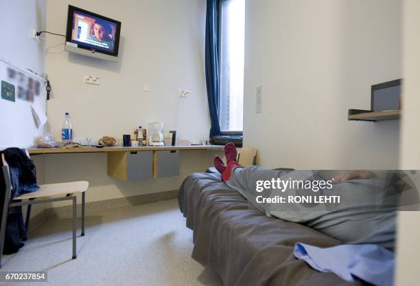 An inmate lays on a bed in his cell in the Saramaki prison in Turku, Finland on July 4, 2008. / AFP PHOTO / Lehtikuva / Roni Lehti / Finland OUT