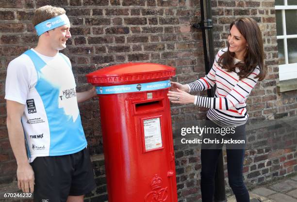 Catherine, Duchess of Cambridge with runner Alex Stanley, put a Heads Together headband onto the Kensington Palace post-box in support of the Royal...