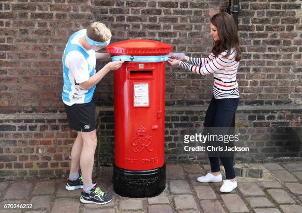 Catherine, Duchess of Cambridge with runner Alex Stanley, put a Heads Together headband onto the Kensington Palace post-box in support of the Royal...