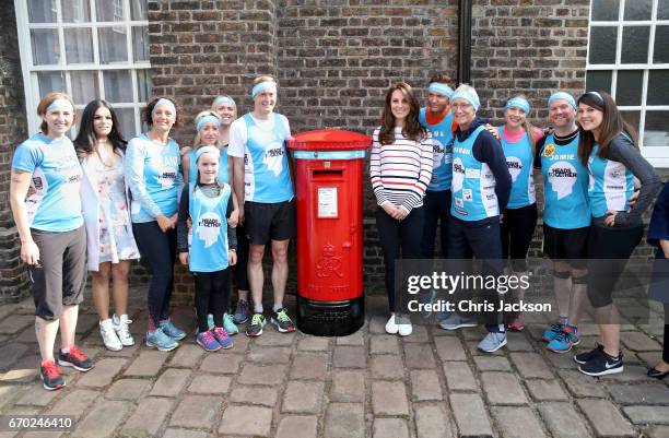 Catherine, Duchess of Cambridge with Alex Stanley and runners as they put a Heads Together headband onto the Kensington Palace post-box in support of...