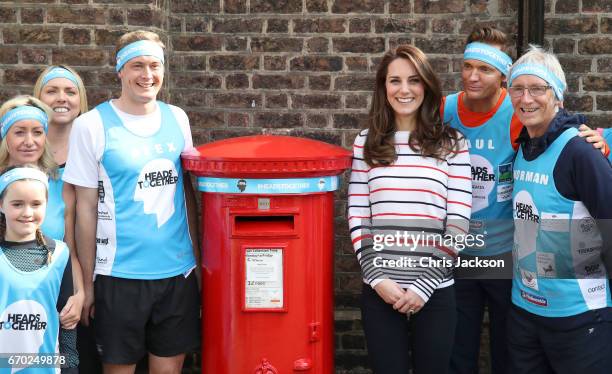 Catherine, Duchess of Cambridge with Alex Stanley and runners as they put a Heads Together headband onto the Kensington Palace post-box in support of...