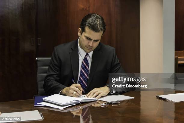 Ricardo Rossello, governor of Puerto Rico, takes notes during a meeting at Puerto Rico Industrial Development Company headquarters in San Juan,...