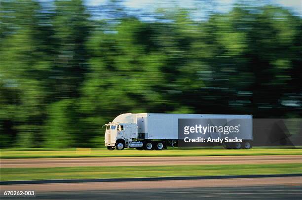 long-bodied commercial truck on rural road (blurred motion) - long road stockfoto's en -beelden