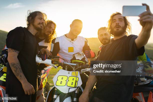 team of dirt bike racers taking selfie at sunset. - motocross imagens e fotografias de stock