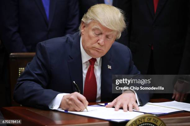 President Donald Trump signs the Veterans Choice Program And Improvement Act in the Roosevelt Room at the White House April 19, 2017 in Washington,...